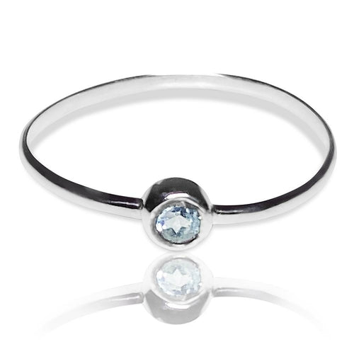Sterling silver ring featuring a dainty blue topaz solitaire tube setting, designed by Grey Clymene.