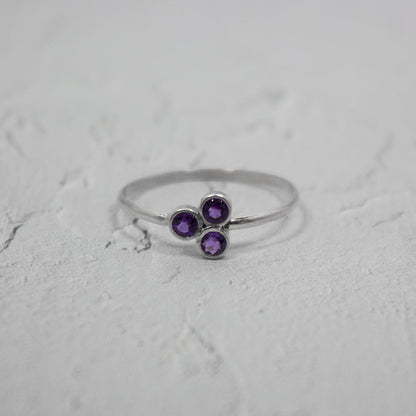 Sterling silver ring featuring a purple amethyst cluster gemstone, elegant jewelry piece with intricate silver detailing.
