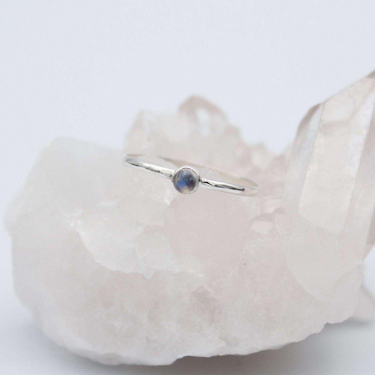 Dainty rainbow moonstone round bezel sterling silver ring from Grey Clymene featuring a smooth, polished gemstone setting.