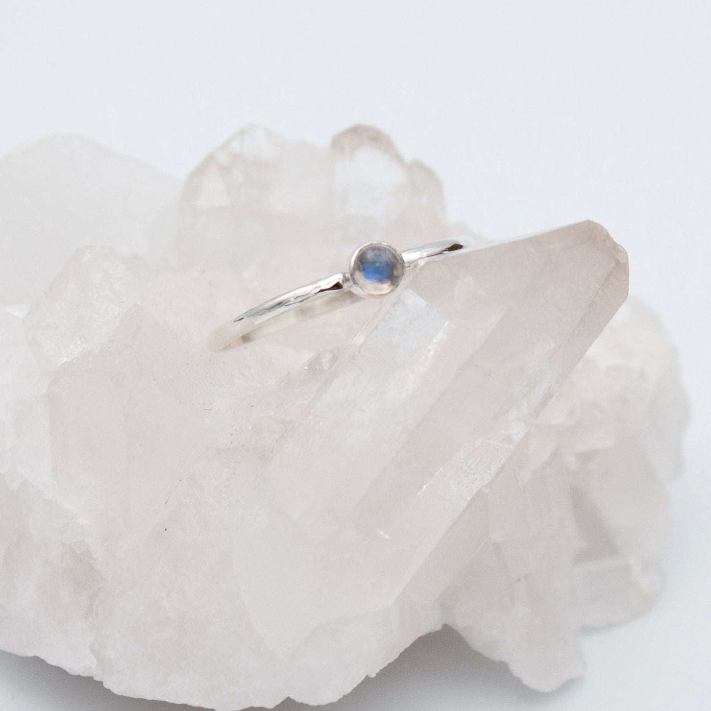 Sterling silver ring featuring a dainty rainbow moonstone in a round bezel setting, from Grey Clymene jewelry collection.