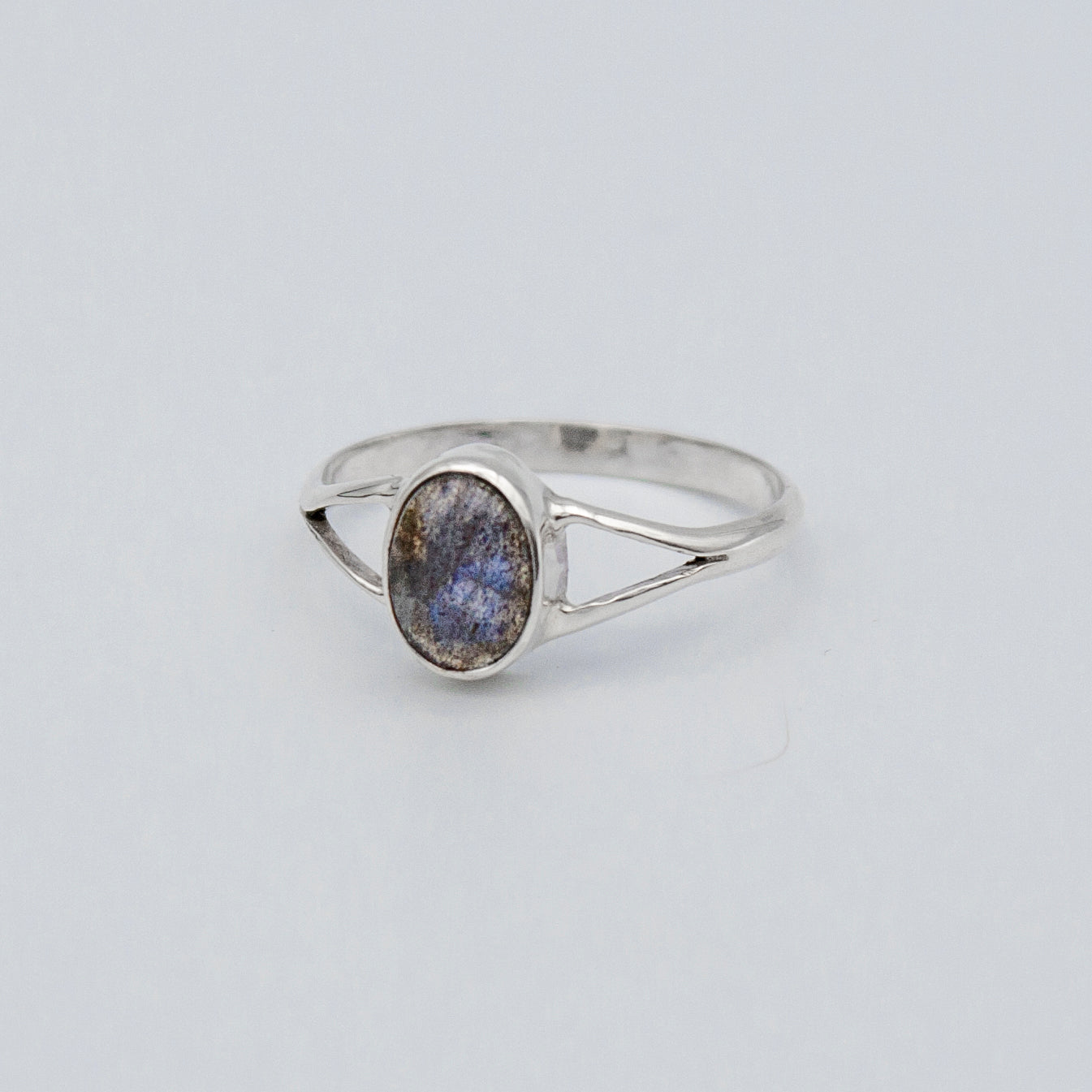 Oval Labradorite bezel split shank sterling silver ring by Grey Clymene featuring a shimmering labradorite stone in a detailed silver setting.