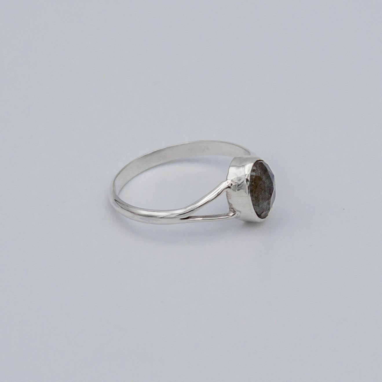 Oval Labradorite bezel split shank sterling silver ring from Grey Clymene with a polished labradorite gemstone and intricate band design.