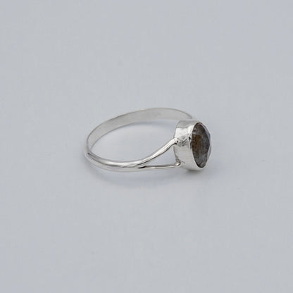 Oval Labradorite bezel split shank sterling silver ring from Grey Clymene with a polished labradorite gemstone and intricate band design.
