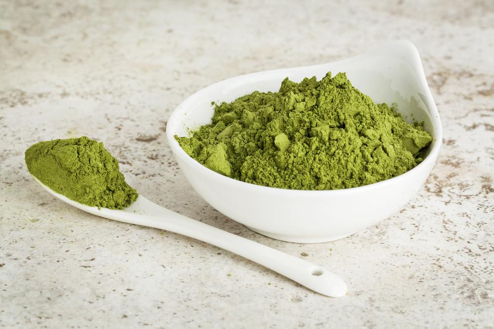 Azure Eurybia Hair Bliss Aloe Vera herbal conditioning powder in a bowl, featuring fresh aloe vera leaves and herbal ingredients.