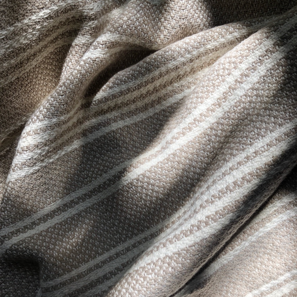 A woven Turkish throw blanket with slate and salt-colored stripes, ideal for home decor, by Ariel.