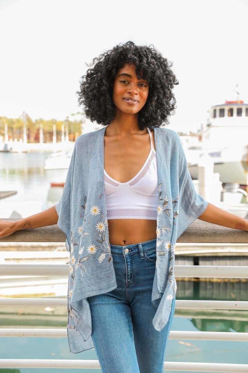 Light chambray Spring Daisy Kimono by Periwinkle Aether featuring floral patterns and flowing fabric, perfect as a stylish blouse.