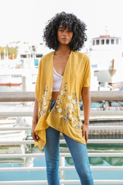 Light blue Spring Daisy Kimono blouse from Periwinkle Aether with floral pattern, flowing fabric, and wide sleeves.
