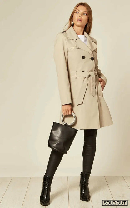 Rose Eleusis spring/summer military double-breasted trench coat in stone, displayed on a hanger, showcasing classic design and fabric details.