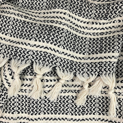 A woven Turkish throw blanket with colorful striped pattern, styled as home decor on a sofa.