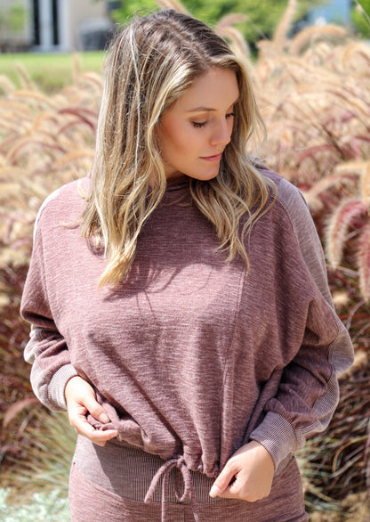 Close-up of taupe Morgan Flared Pants by Brown Tartarus showing ribbed fabric detail and wide-leg silhouette.