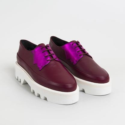 Red Electra Faced fuchsia leather platform creepers with chunky sole and lace-up design, stylish footwear for bold fashion statements.