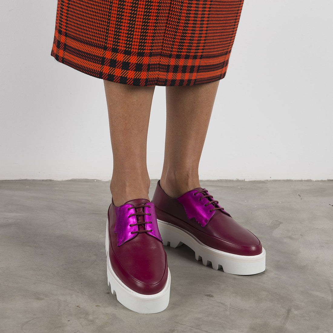 Red Electra Faced fuchsia leather platform creepers with chunky soles and lace-up design, styled as fashionable footwear.