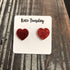 Red glitter heart stud earrings from Olive Felix, close-up view showing shiny heart-shaped earrings with sparkling glitter finish.