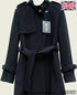 Black collarless trench coat by Rose Eleusis, tailored stylish design, shown on a model wearing it as a jacket or coat.