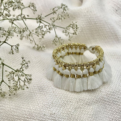 Ariel Kyra tassel bracelet with white fair trade fabric tassels and metal cuff design, stylish and eco-friendly jewelry accessory.